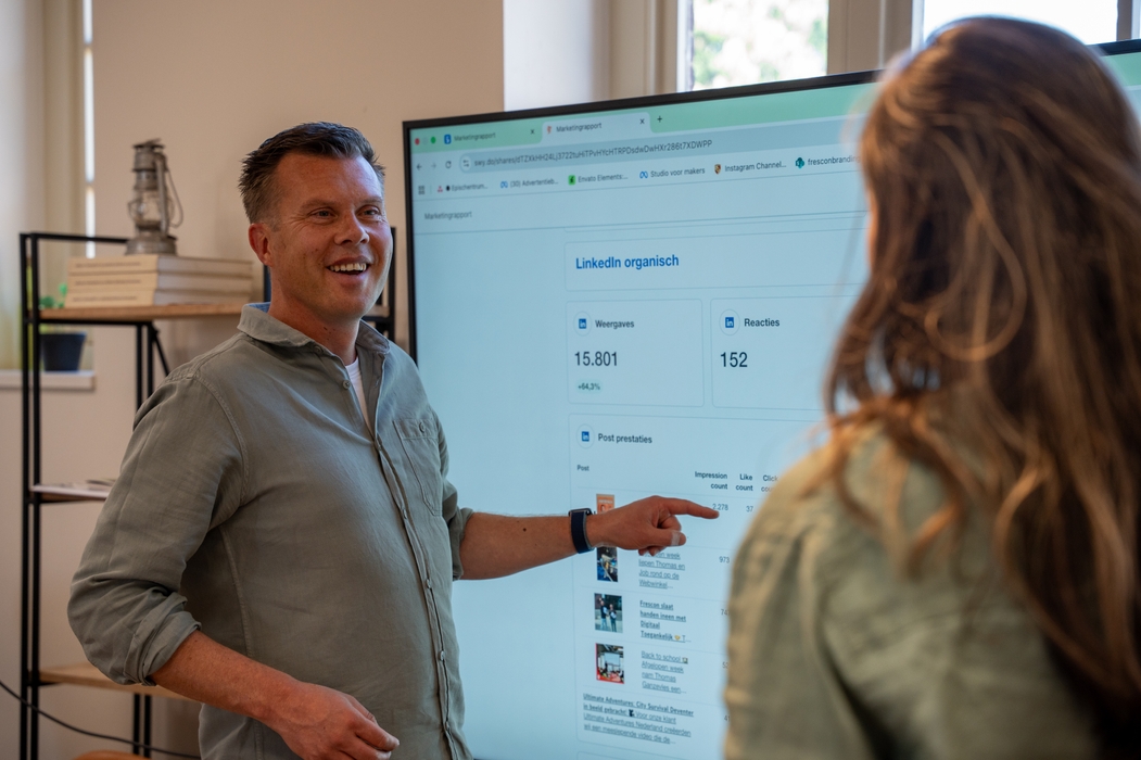 Thomas wijst naar het scherm met swydo dashboard gegevens