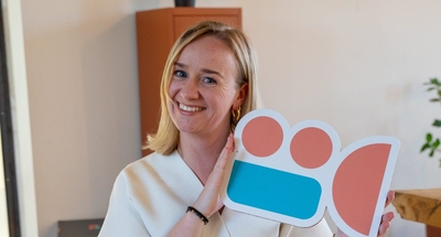 Glimlachende vrouw houdt Frescon-filmcamera-logo vast.