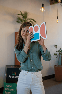 Vrouw knipoogt en houdt een filmcamera-icoon vast.